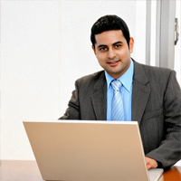 Hombre de negocios con traje y corbata trabajando en una laptop en una oficina moderna